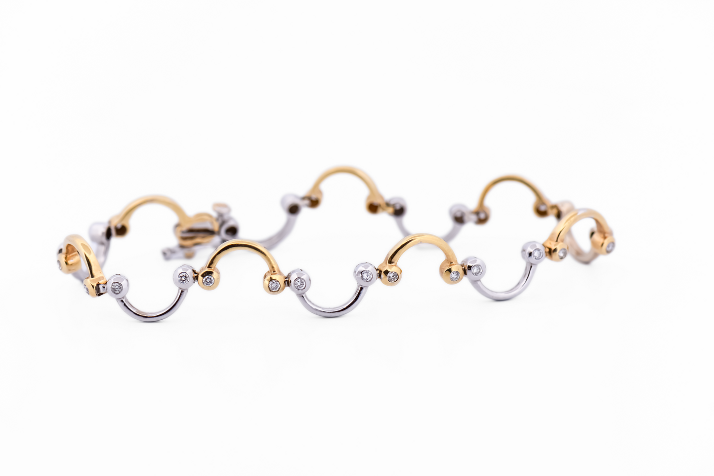 Swirling Two-Tone Gold Link Bracelet with Bezel Set Diamond Accents