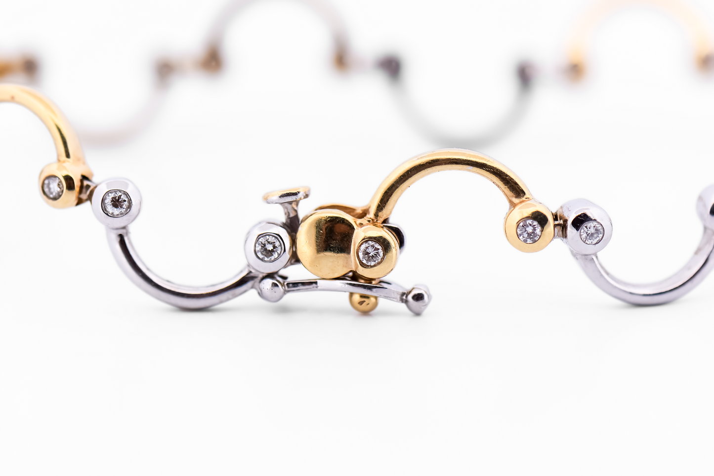 Swirling Two-Tone Gold Link Bracelet with Bezel Set Diamond Accents